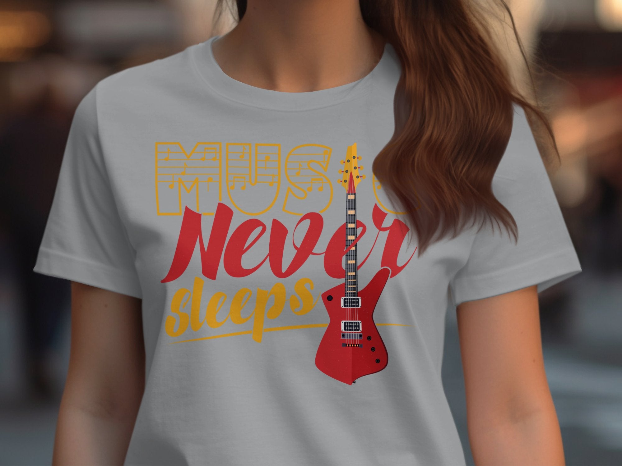 A person wearing a Garment Graphics T-shirt featuring the design Music Never Sleeps in vibrant red and yellow fonts, showcasing an eye-catching red electric guitar against a blurred backdrop.