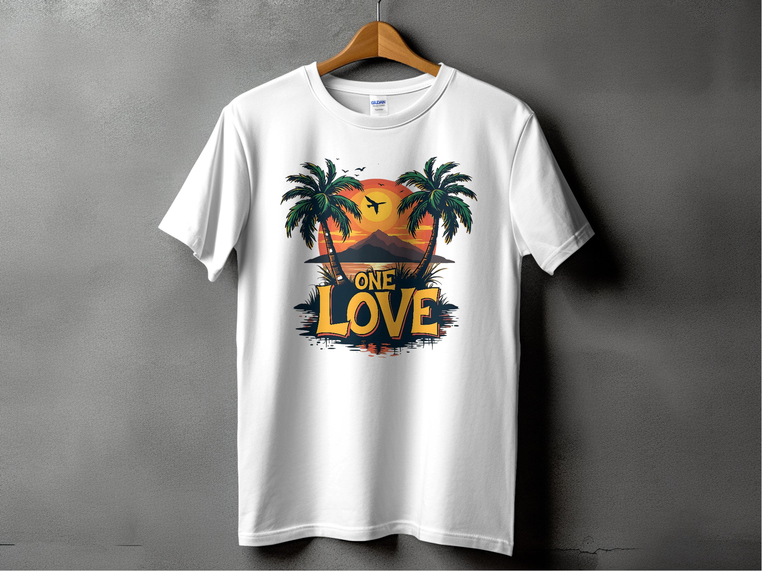 A white T-shirt by Garment Graphics, hanging on a plain gray wall, features palm trees, a tropical sunset, and a bird in flight. One Love is printed at the bottom—ideal for beach lovers.