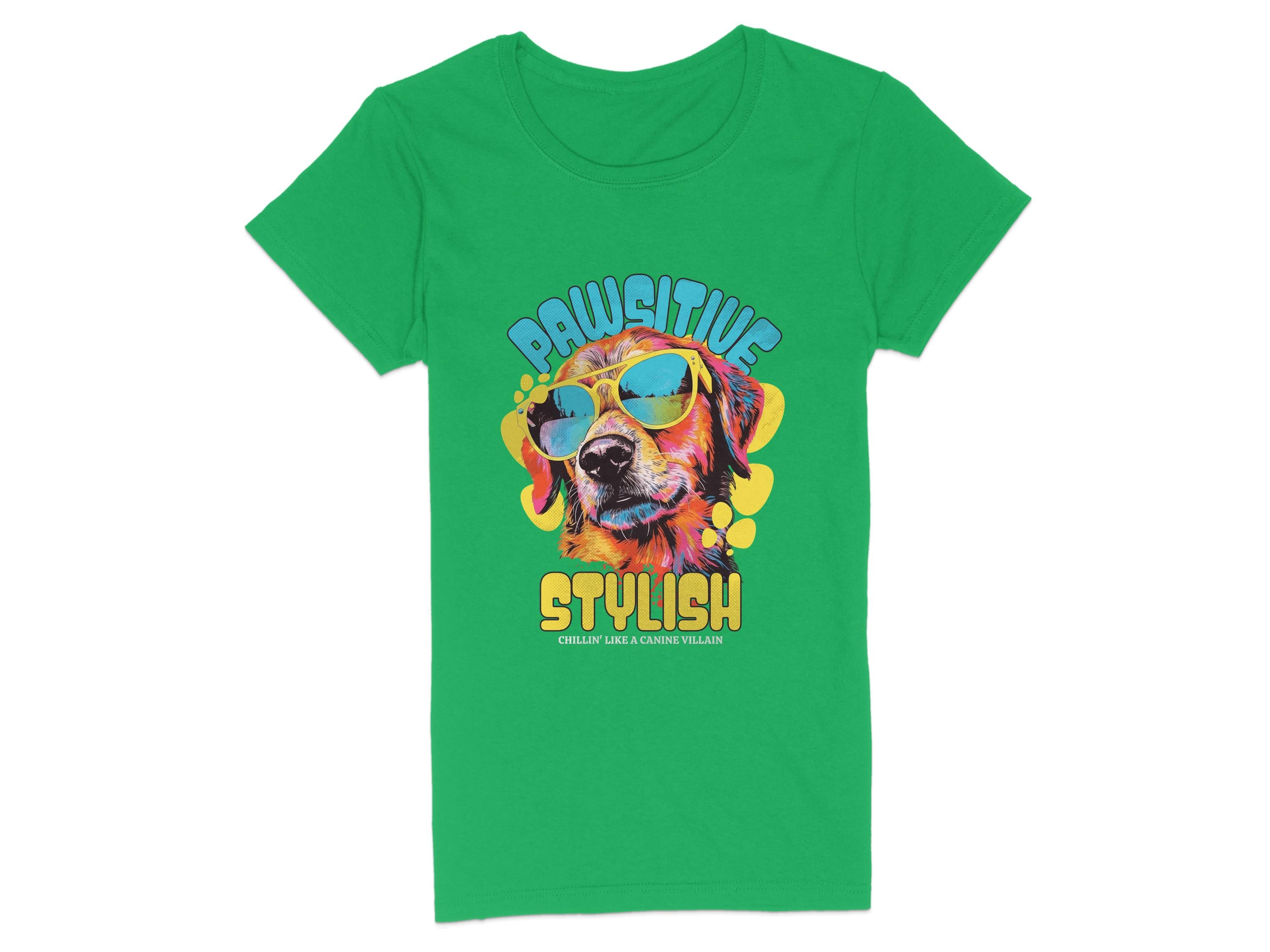 A green Dog T-Shirt by Garment Graphics showcases a vibrant dog with sunglasses graphic. The text Pawsitive appears above, and Stylish with smaller text below, surrounded by colorful splashes. Available in womens sizing.