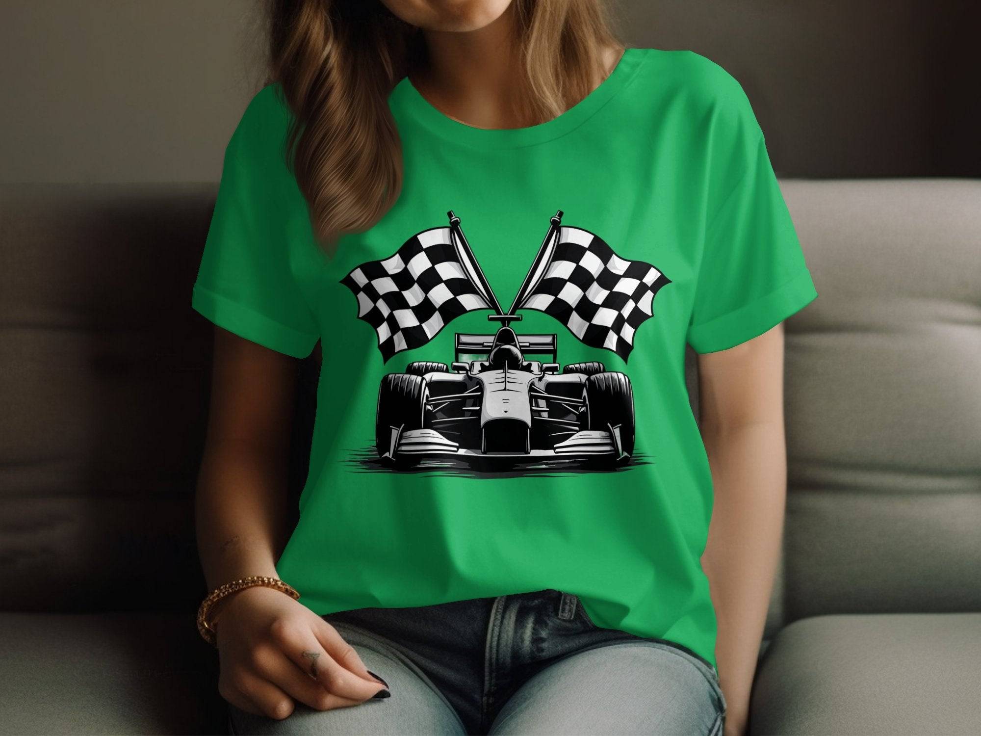 A person wearing a green Garment Graphics T-shirt featuring a race car and crossed checkered flags, ideal for motorsport fans, sits on a couch. Their left hand rests on their knee, dressed in blue jeans.
