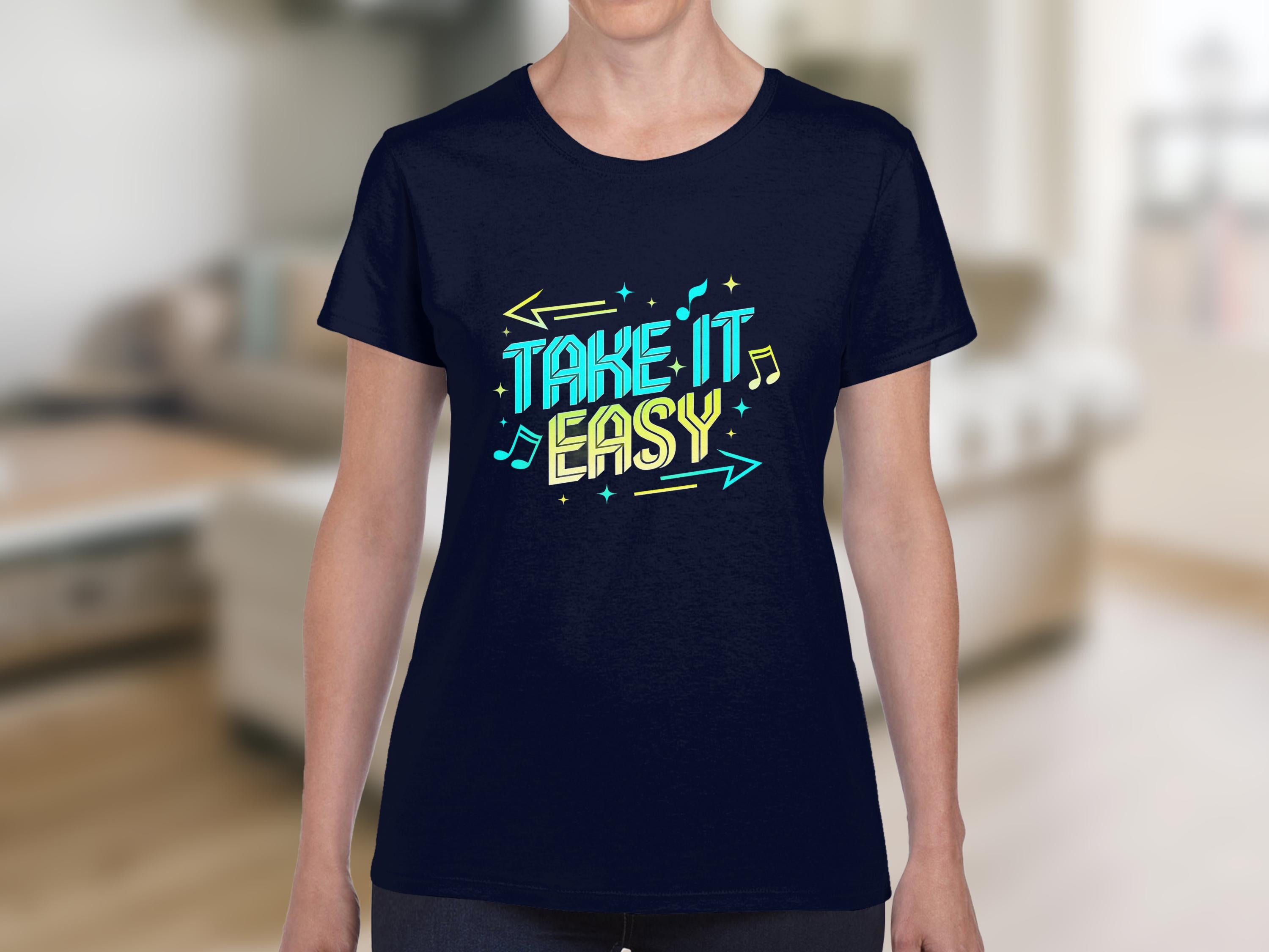 A person in a Garment Graphics dark blue t-shirt showcases vibrant graphics with Take It Easy, musical notes, and arrows, set against a blurred indoor backdrop with light-colored furniture, highlighting the shirts stylish design.