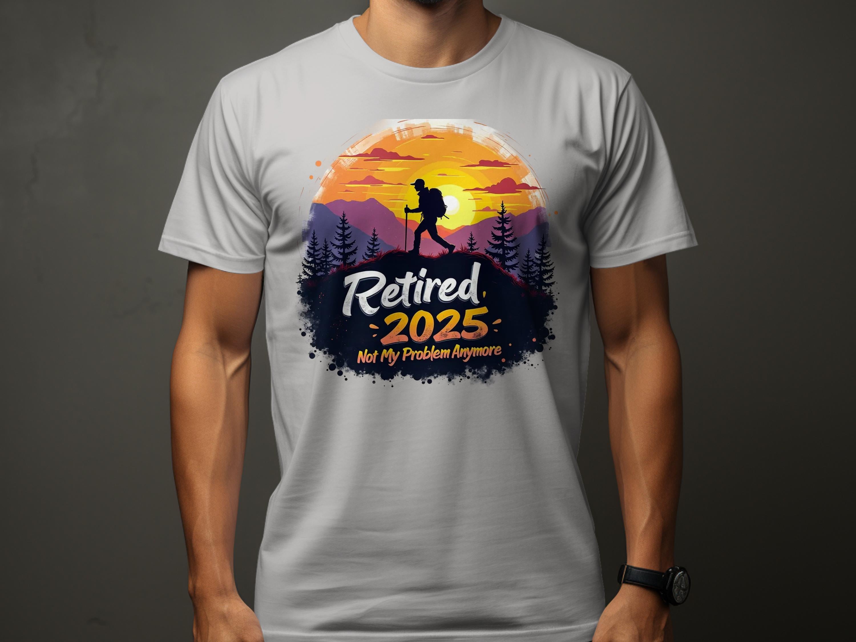 A person wears a Garment Graphics light gray T-shirt with a hiker silhouette against a sunset and trees. Retired 2025 Not My Problem Anymore text captures retirement vibes, set on a dark gray contrast.
