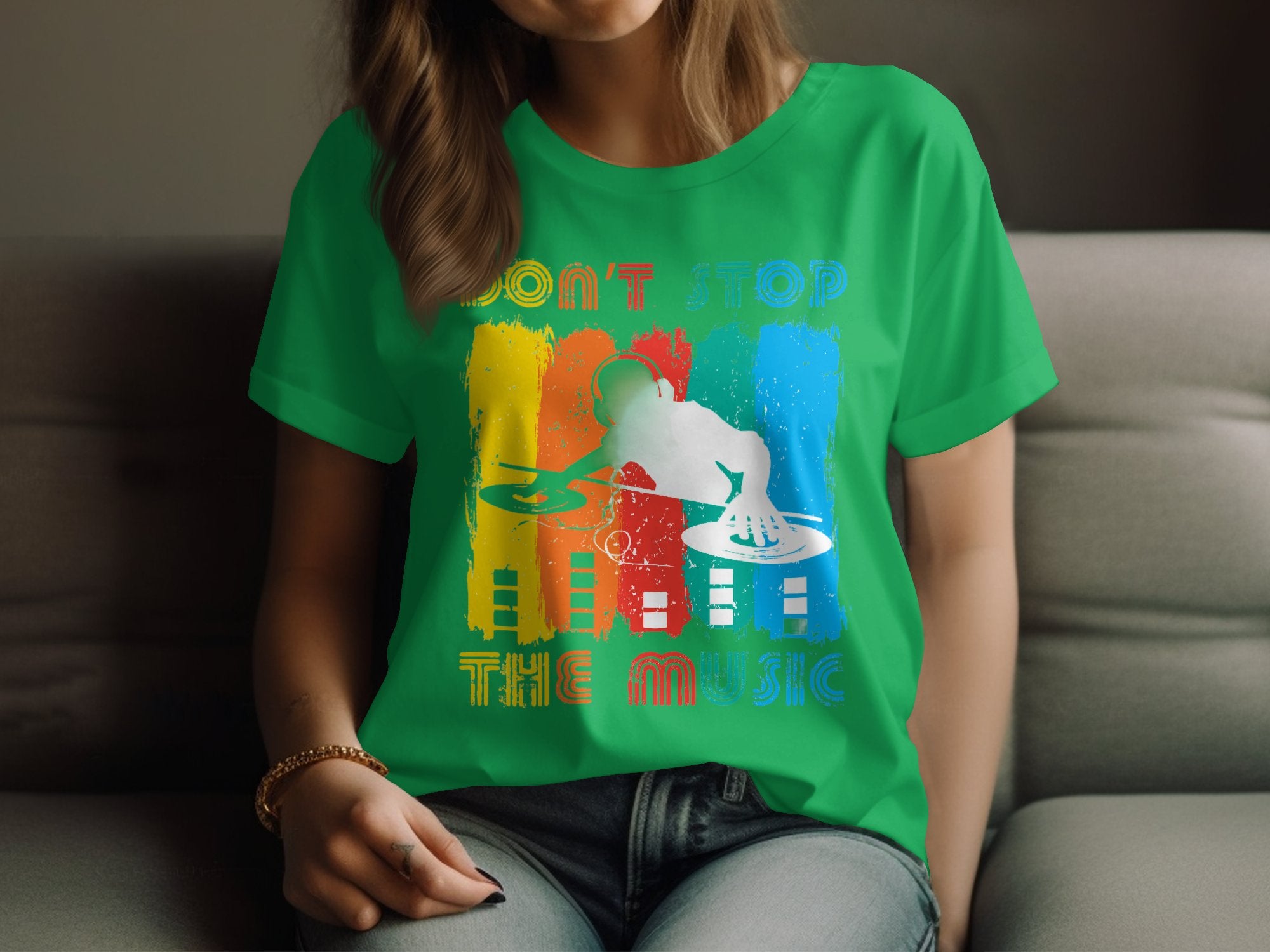 A person on a couch in a vibrant Garment Graphics DJ tee featuring Dont Stop the Music in colorful design, ideal for music lovers.