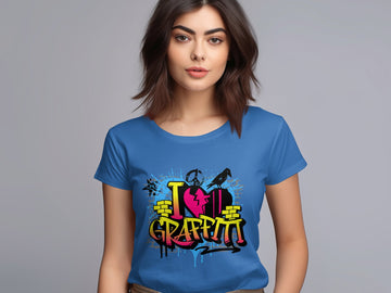 A woman with long brown hair dons a blue Garment Graphics T-shirt featuring vibrant street art and the phrase I Love Graffiti in stylized letters, standing against a plain light gray backdrop and embodying urban design spirit.