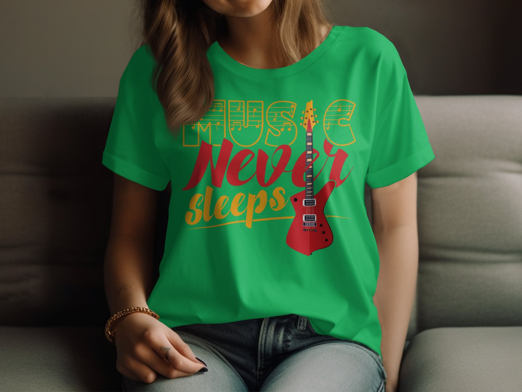 A person sits on a couch wearing a vibrant green Garment Graphics shirt, featuring the text Music Never Sleeps with a bold red electric guitar graphic. Only their lower face and torso are visible, making this unique t-shirt perfect for guitar enthusiasts.