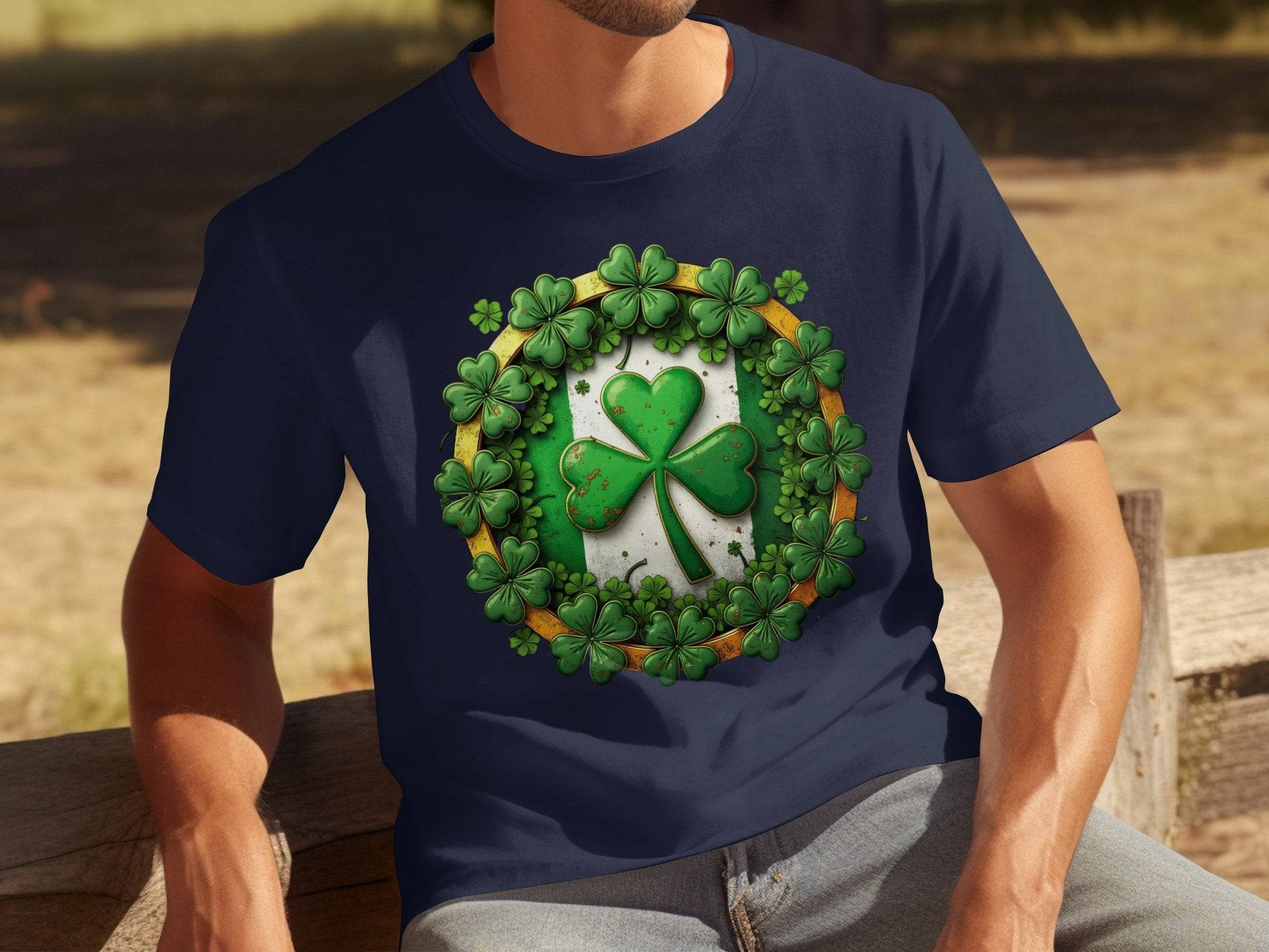 A person is wearing Garment Graphics navy blue T-shirt, ideal for St Patricks Day. It has a vibrant green and white shamrock clover design, with large and smaller clovers. They are sitting relaxed on a wooden bench outside, soaking in the festive charm.