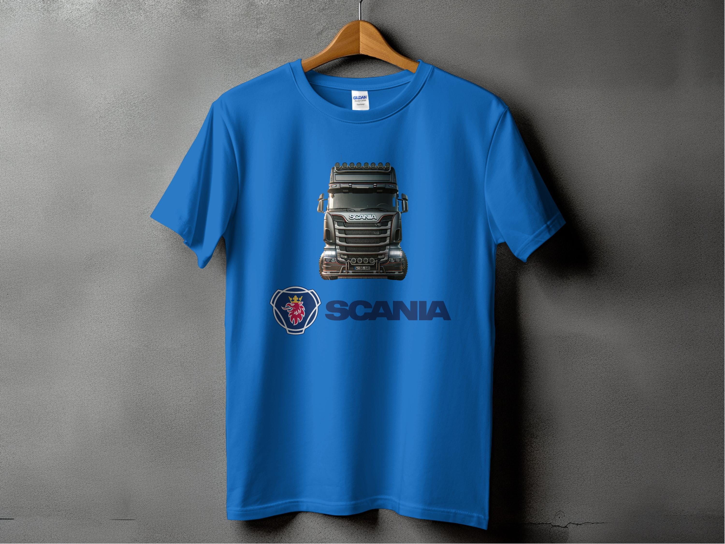 A blue t-shirt from Garment Graphics on a hanger showcases a Scania truck graphic, ideal for truck fans. The t-shirt features the Scania logo and name below the image, set against a plain gray wall.