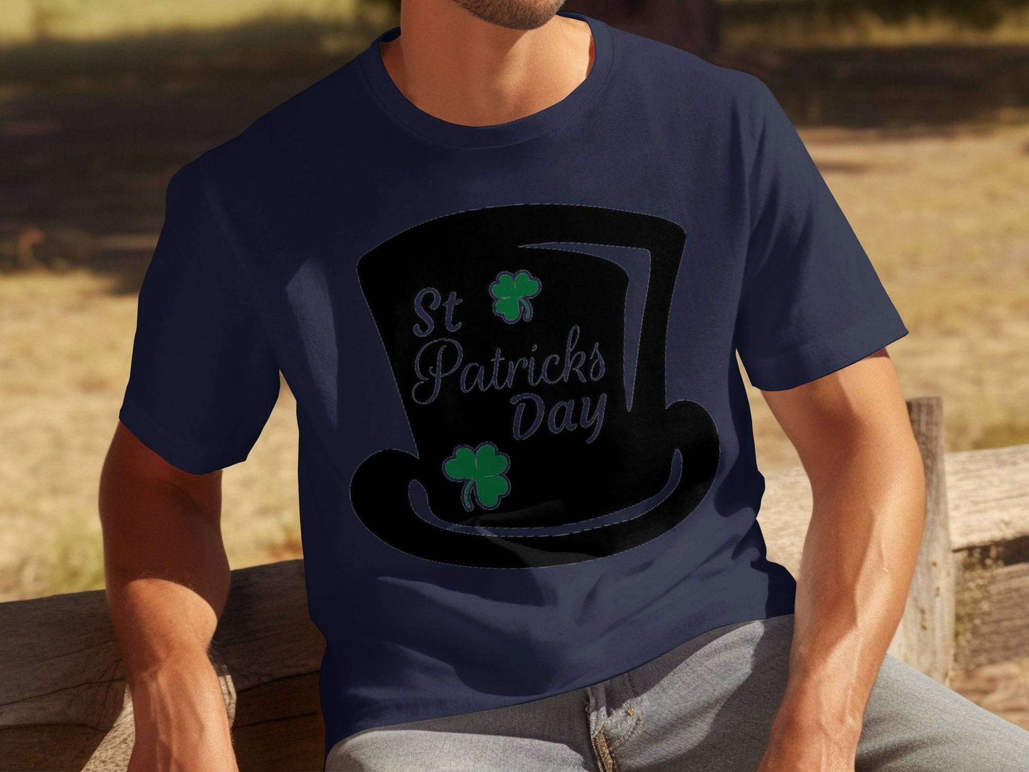 A person relaxes on a wooden bench wearing Garment Graphics navy T-shirt featuring a black top hat decorated with green shamrocks and four-leaf clovers, elegantly adorned with the words St Patricks Day.