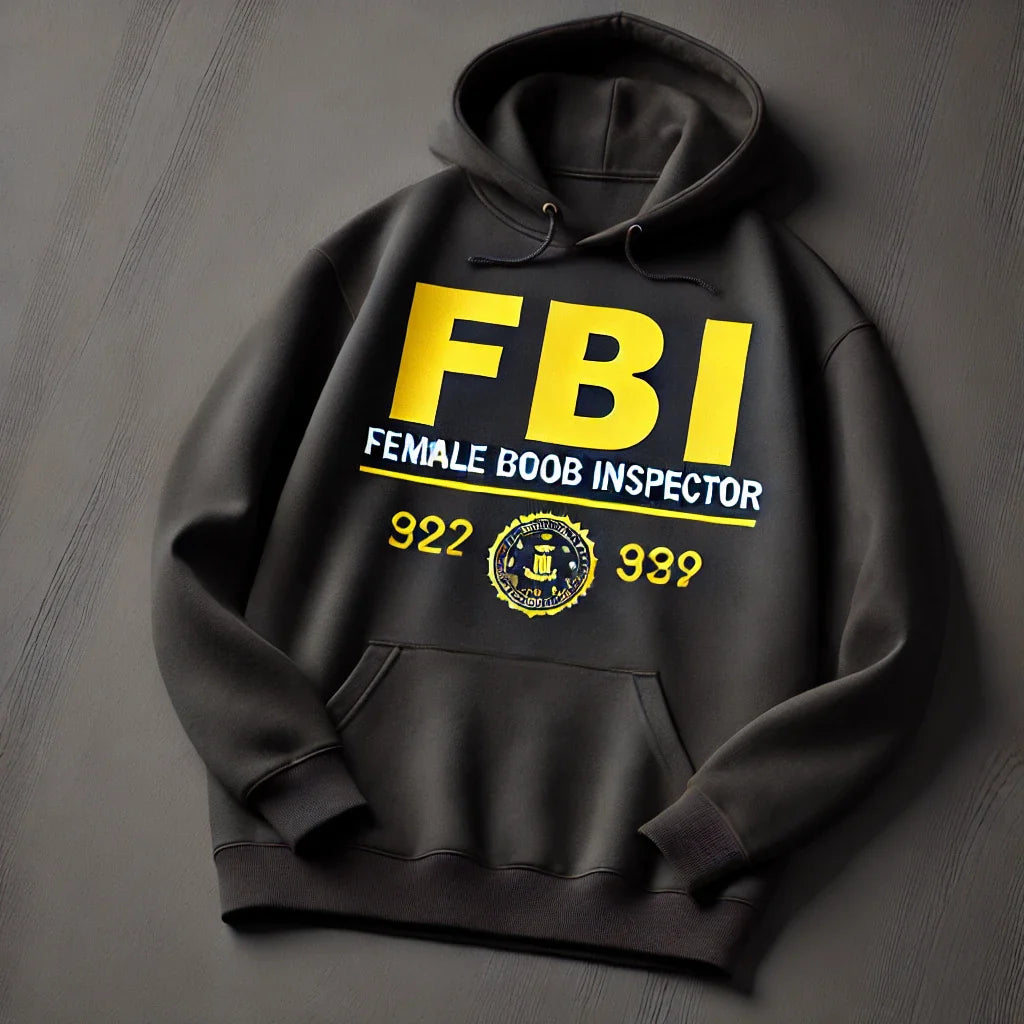 A black hoodie with yellow letters reading FBI and smaller text below saying Female Boob Inspector. It also displays numbers 922 and 989 and a circular emblem at the bottom.