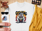 A Garment Graphics white Bulldog Sweatshirt features a bulldog with a gold chain and City King. Its surrounded by sunglasses, makeup brushes, a yellow blazer, pink shoes, a blue pouch, lipstick, foundation, and an eyeshadow palette on a wooden surface.