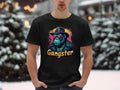 In an urban snowy setting, a person wears Garment Graphics black t-shirt featuring a colorful graphic of a chimpanzee in gangster attire with Gangster boldly printed below, embodying the classic fit essence.