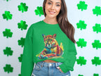 A person with long hair wears a green, unisex Garment Graphics sweatshirt featuring a vibrant colorful cougar design. Green shamrock cutouts on a white wall in the background enhance the unique style.
