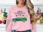 Sporting a pink Garment Graphics festive sweatshirt with a green truck, shamrocks, and Happy St. Patricks Day, one stands by shelves filled with holiday ornaments and a small Christmas tree.