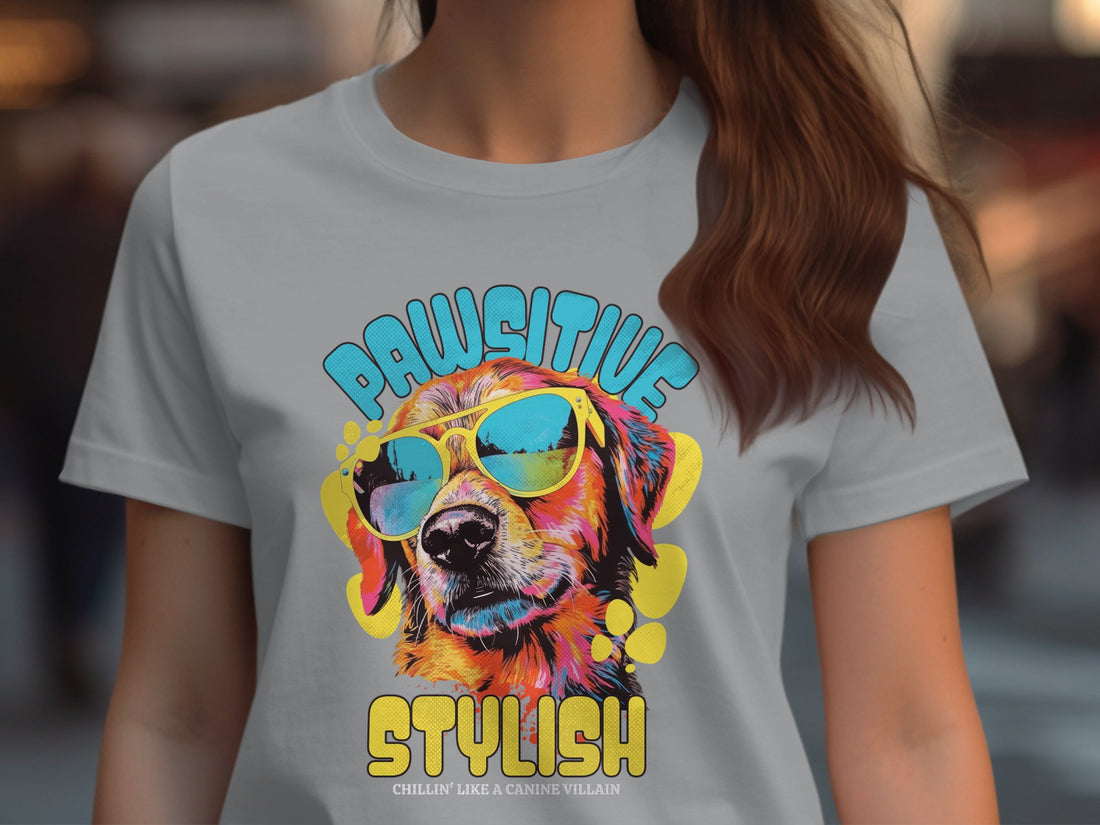 Garment Graphics presents a white T-shirt with a vibrant dog in sunglasses and the text Pawsitive Stylish. Includes Gildan 5000L Heavy Cotton Womens size chart from S to 3XL in inches. A perfect blend of style and comfort.