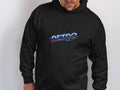 A person confidently wears a black RETRO hoodie from Garment Graphics, featuring a vivid futuristic font, standing against a plain white background.