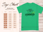 Garment Graphics offers a green Happy St. Patricks Day t-shirt featuring a green pickup truck graphic that celebrates Irish pride. Available in sizes S to 5XL, the Gildan 5000 heavy cotton tee has a detailed size chart on the left. The background is light wood.