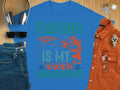 The Garment Graphics blue fishing T-shirt boldly states Fishing Is My Anger Management in vibrant green and orange, featuring a fish and lure. Paired with jeans, sunglasses, headphones, a watch, and a brown shirt on wood—ideal for any fishing enthusiasts casual day out.