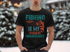A fishing enthusiast sports a Garment Graphics black T-shirt featuring Fishing is my anger management in bold blue and orange text, standing against a serene snowy landscape with blurred evergreen trees.