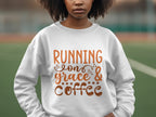 A person wearing a Garment Graphics sweatshirt with Running on Grace & Coffee in brown script stands on a sports field. The unisex sizing ensures comfort for all, with an artfully blurred background.