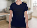 Wearing a Garment Graphics semi-fitted navy T-shirt featuring Cleverly Disguised As A Responsible Adult in black, the person stands confidently amidst a blurred living room setting, adding a humorous touch.