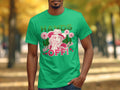 A man wears Garment Graphics bold green t-shirt featuring a graphic of a hatted person with flowers, striking HANDS OFF! text, and smaller wild and safe letters. This classic fit shirt stands out against the parks trees and blurred paths.