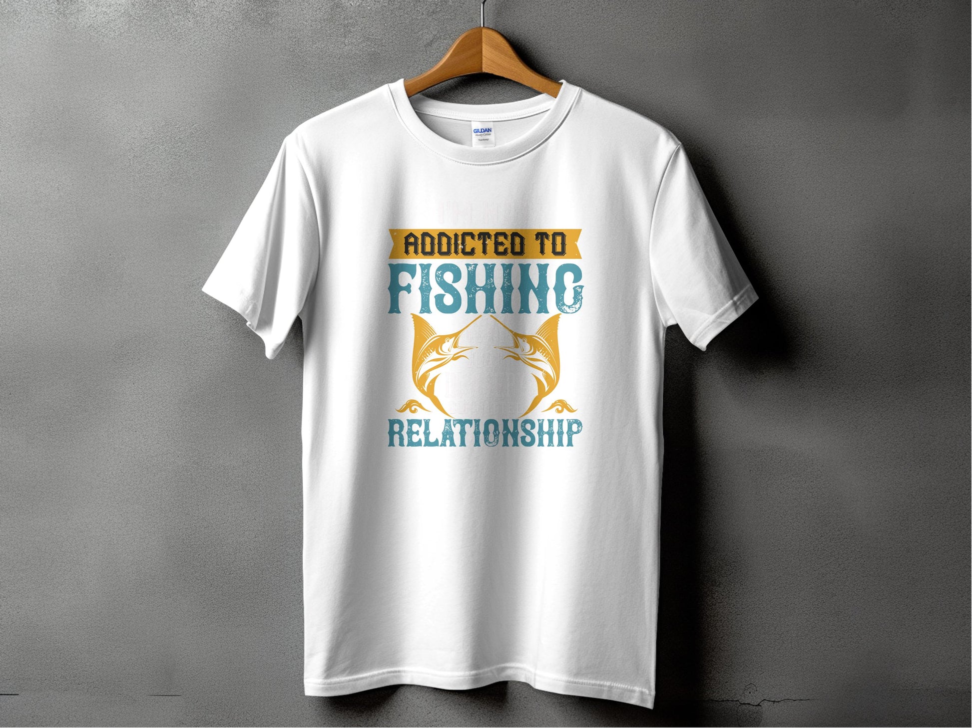 Garment Graphics white fishing T-shirt displays Addicted to Fishing Relationship in orange and blue on a wooden hanger, featuring two stylized fish facing each other—ideal for passionate anglers.