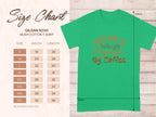 A green Garment Graphics heavy cotton T-shirt, classic fit, with This Day Is Powered by Coffee in orange. Ideal for coffee lovers, it includes a size chart from S to 5XL on the left, detailing width and length for the best fit.