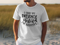 Wearing a Garment Graphics T-shirt with the slogan, I Had My Patience Tested, Im Negative, someone exudes sarcasm amidst tall grass and a softly blurred landscape.