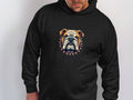 Wearing a black hoodie from Garment Graphics featuring a bulldog with a spiked collar design on the front, the individual makes a bold statement against a plain white background.