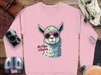 The Garment Graphics sweatshirt features a pink llama with red sunglasses and No Prob-Llama text, surrounded by a camera, binoculars, leather pouch, and maps on wood. This fun design provides unisex sizing for ultimate comfort and style.