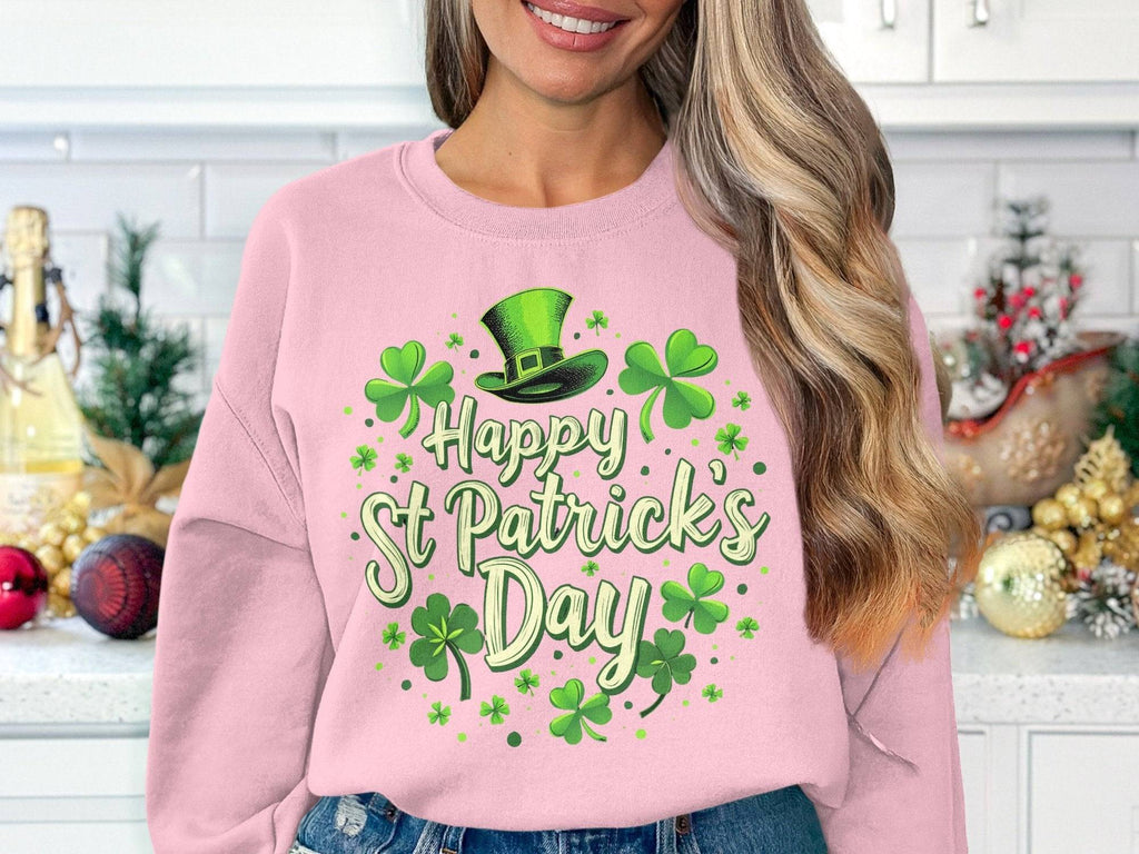Wearing a Garment Graphics pink sweatshirt with a vibrant shamrock and Happy St Patricks Day in green, festive charm fills the decorated kitchen counter, adorned with holiday ornaments and accompanied by a leprechaun hat.