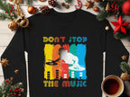 The Garment Graphics black sweater boasts a vivid DJ design with DONT STOP THE MUSIC text, encircled by holiday décor such as ornaments, pine branches, cinnamon sticks, and a coffee cup on wood—ideal for music lovers this season.