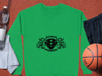 A green Scania Power 8 logo sweatshirt with stylized lion heads from Garment Graphics, is displayed alongside a basketball, black shorts, a water bottle, and a rolled-up towel on a textured surface.