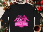 A black sweatshirt from Garment Graphics is on a wooden surface with Christmas decorations. It features a pink graphic of three women, palm trees, and the phrase ALWAYS PARTY BEACH GIRL. A steaming cup of coffee sits nearby.