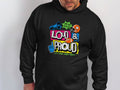 A person proudly wears a black Garment Graphics hoodie featuring the bold phrase Loud & Proud and lively sports graphics like megaphones and helmets, ideal for noise-loving fans.