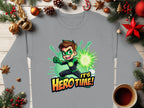 A Garment Graphics gray long-sleeved shirt, featuring an adventure-loving youth in a vibrant Its Herotime graphic sweatshirt, is laid on a wooden table. Surrounded by festive decorations and a steaming cup of coffee, its colorful design exudes excitement and fun.