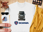 The graphic crewneck sweatshirt by Garment Graphics, featuring a Scania truck image and logo, is displayed on a wooden surface with pink shoes, sunglasses, makeup brushes, a makeup palette, nail polish, a pink velvet pouch, and a mustard-yellow jacket—ideal for stylish truck enthusiasts.