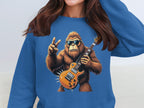 A person wearing a Garment Graphics sweatshirt showcasing a blue rocking gorilla. The gorilla sports sunglasses, holding an electric guitar and making a peace sign, ideal for music enthusiasts.