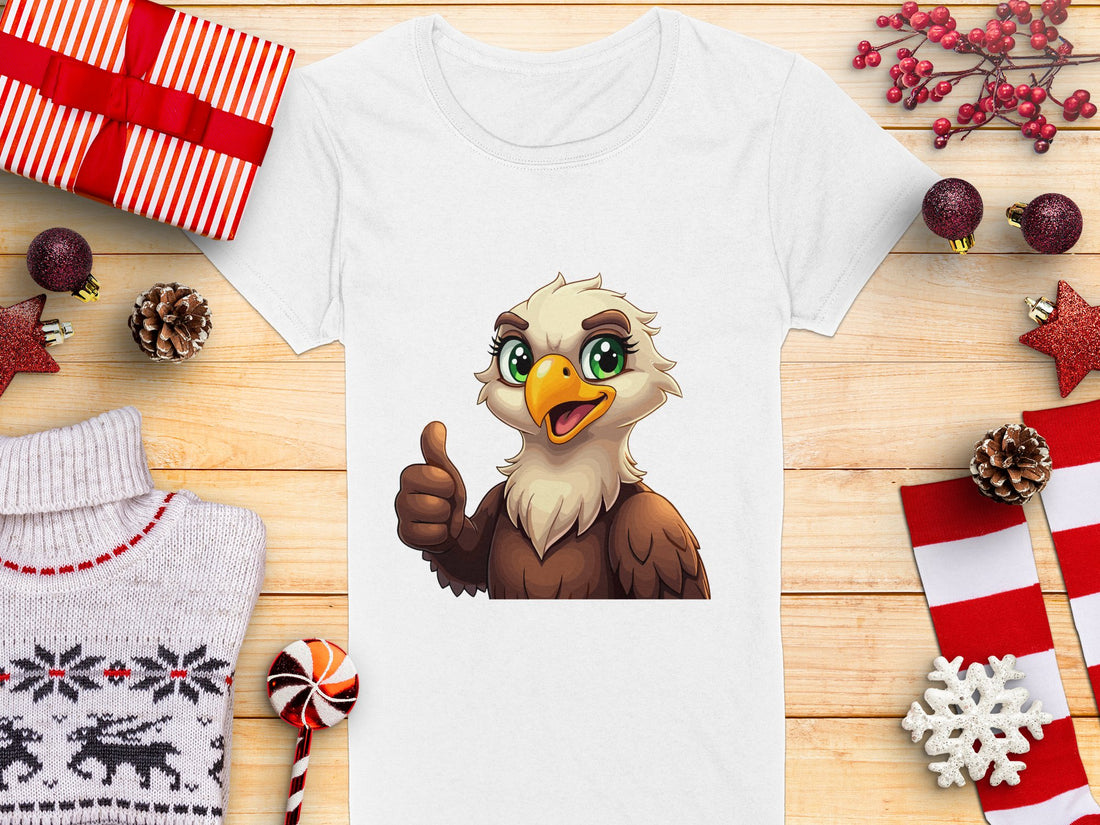 A woman with brown hair wears a Garment Graphics blue cartoon T-shirt featuring an eagle giving a thumbs up, ideal for animal lovers. The background is plain grey.