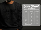 Someone sporting a black Garment Graphics sweatshirt with Cleverly Disguised as a Responsible Adult brings humor to their outfit. A size chart for unisex Gildan 18000 sweatshirts details sizes S-5XL, along with the corresponding widths and lengths in inches.