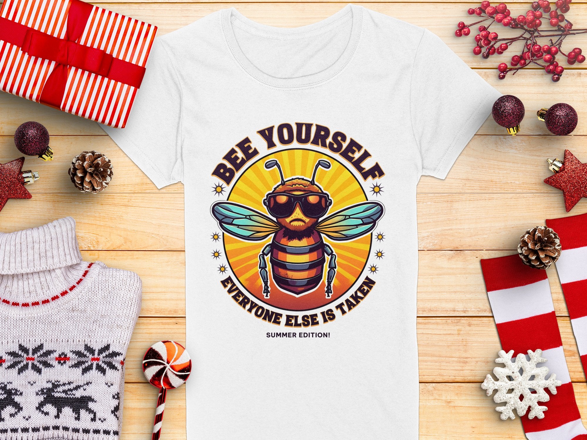 Garment Graphics offers a womens white t-shirt featuring a bee in sunglasses and headphones, with the message Bee Yourself, Everyone Else is Taken. Summer Edition! Perfect for fans of Bee Yourself T-Shirts, its displayed on wood with holiday decor and gifts nearby.