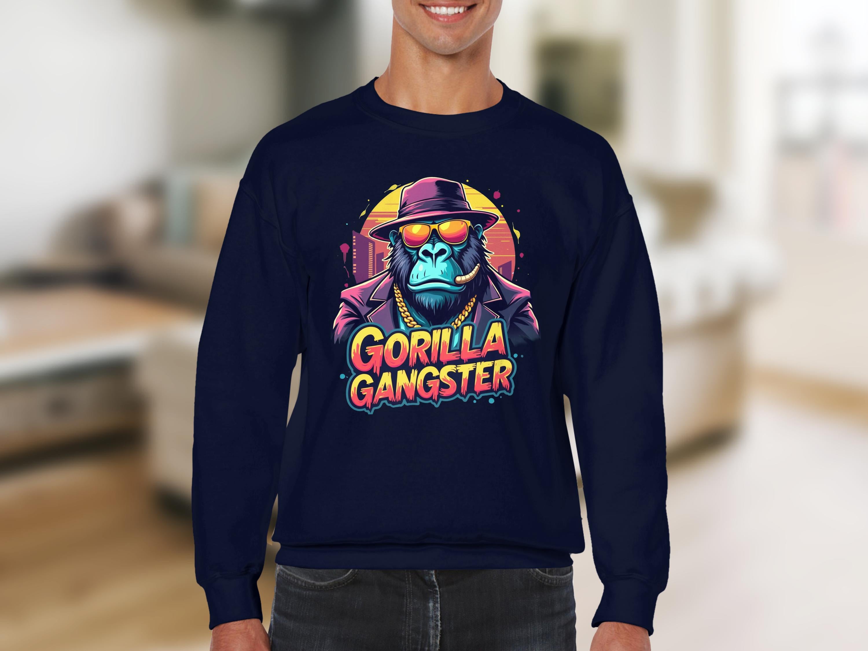 A person in an urban style navy sweatshirt by Garment Graphics features a vibrant gorilla wearing sunglasses and a hat with Gorilla Gangster boldly displayed below, set against a blurred indoor backdrop.
