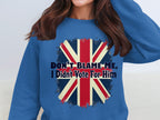 A person wears a blue sweatshirt by Garment Graphics with the Union Jack and bold text DONT BLAME ME, I Didnt Vote For Him, available in unisex sizing for a perfect fit.