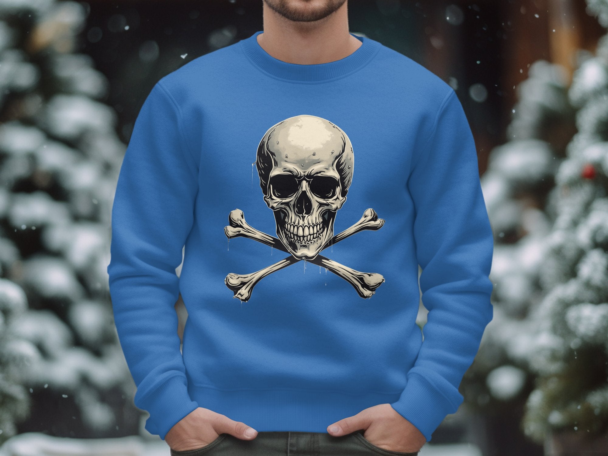 Wearing Garment Graphics blue skull and crossbones graphic print sweatshirt, a person stands amidst snow-covered trees, their edgy style contrasting the serene winter landscape.