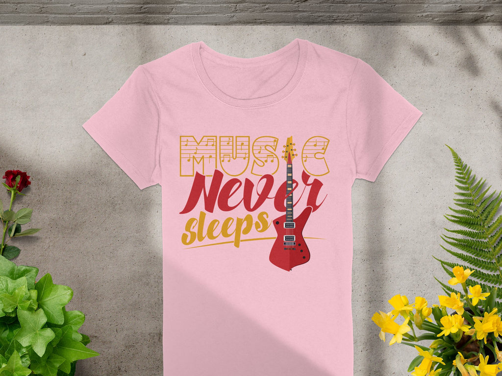 The Garment Graphics t-shirt showcases the vibrant Music Never Sleeps slogan in bold yellow and red with a striking red electric guitar. Its displayed on concrete, surrounded by lush green and yellow plants, capturing the essence of guitar t-shirts for music enthusiasts.