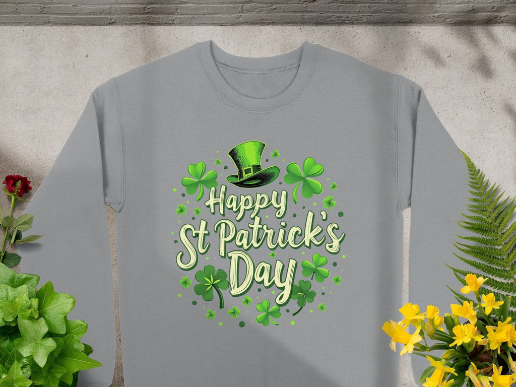 Garment Graphics presents a gray sweatshirt that exudes St. Patricks Day cheer with vibrant green Happy St Patricks Day print, shamrocks, and a jaunty top hat. Displayed on concrete, its paired with lush green plants and bright yellow flowers.