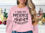 Sporting a pink I had my patience tested Im negative sweatshirt by Garment Graphics, designed with unisex sizing, a joyful person beams in a holiday-themed kitchen. Ideal for casual wear and those seeking quirky charm.