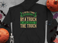 Garment Graphics offers a black hoodie with the humorous quote If an Englishman gets run down by a truck, he apologizes to the truck in yellow and green. Surrounded by Halloween motifs like bats, skeletons, pumpkins, and spiders, it humorously reflects English etiquette.