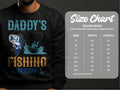 A man wears a Garment Graphics sweatshirt featuring a playful blue fish and boat design with Daddys Fishing Buddy, ideal for outdoor lovers. Next to him is the Gildan 18000 Heavy Blend Crewneck size chart showing sizes and measurements.