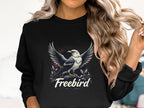 A person with long wavy hair wears a black Garment Graphics Freebird Sweatshirt showcasing an eagle in flight. It offers unisex sizing, ensuring a comfy fit for all.